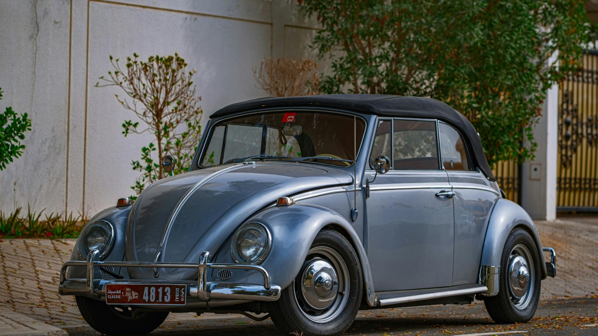 Blauer Oldtimer parkt in der Nähe des weißen Gebäudes