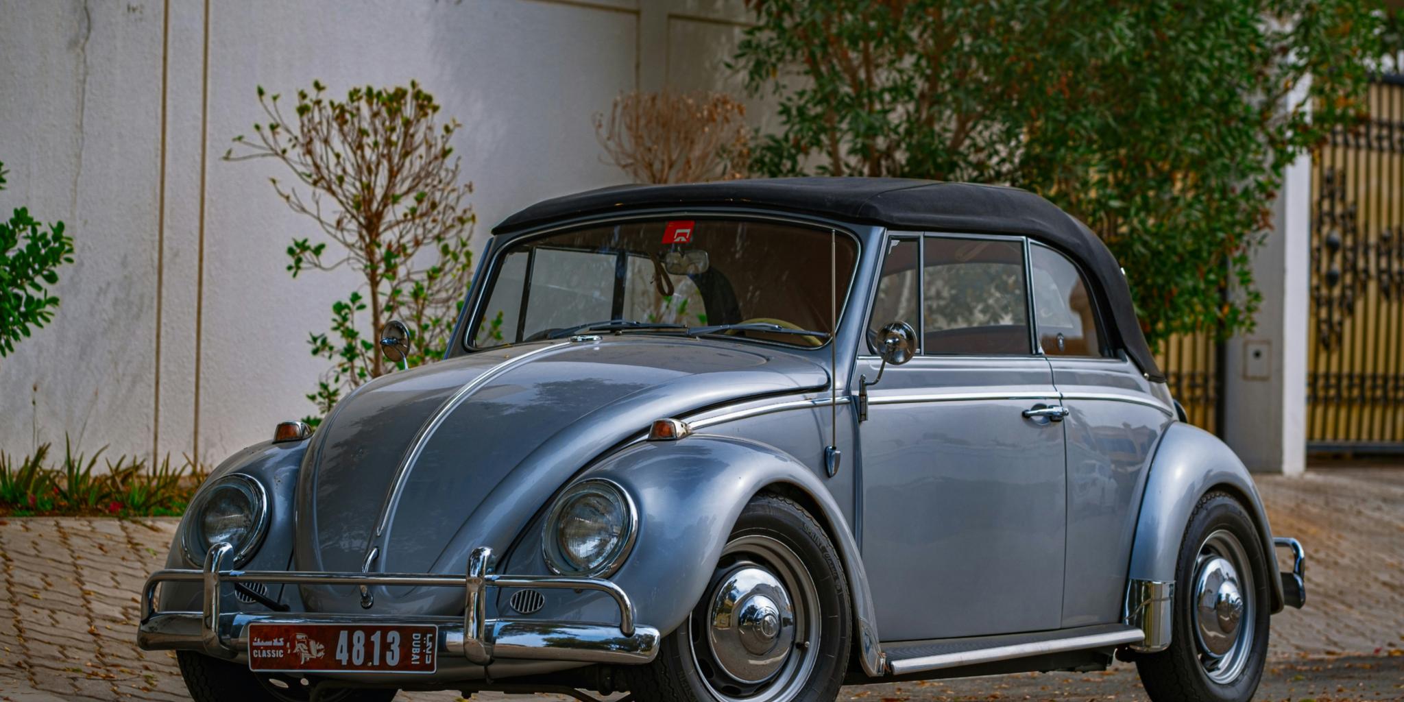 Blauer Oldtimer parkt in der Nähe des weißen Gebäudes